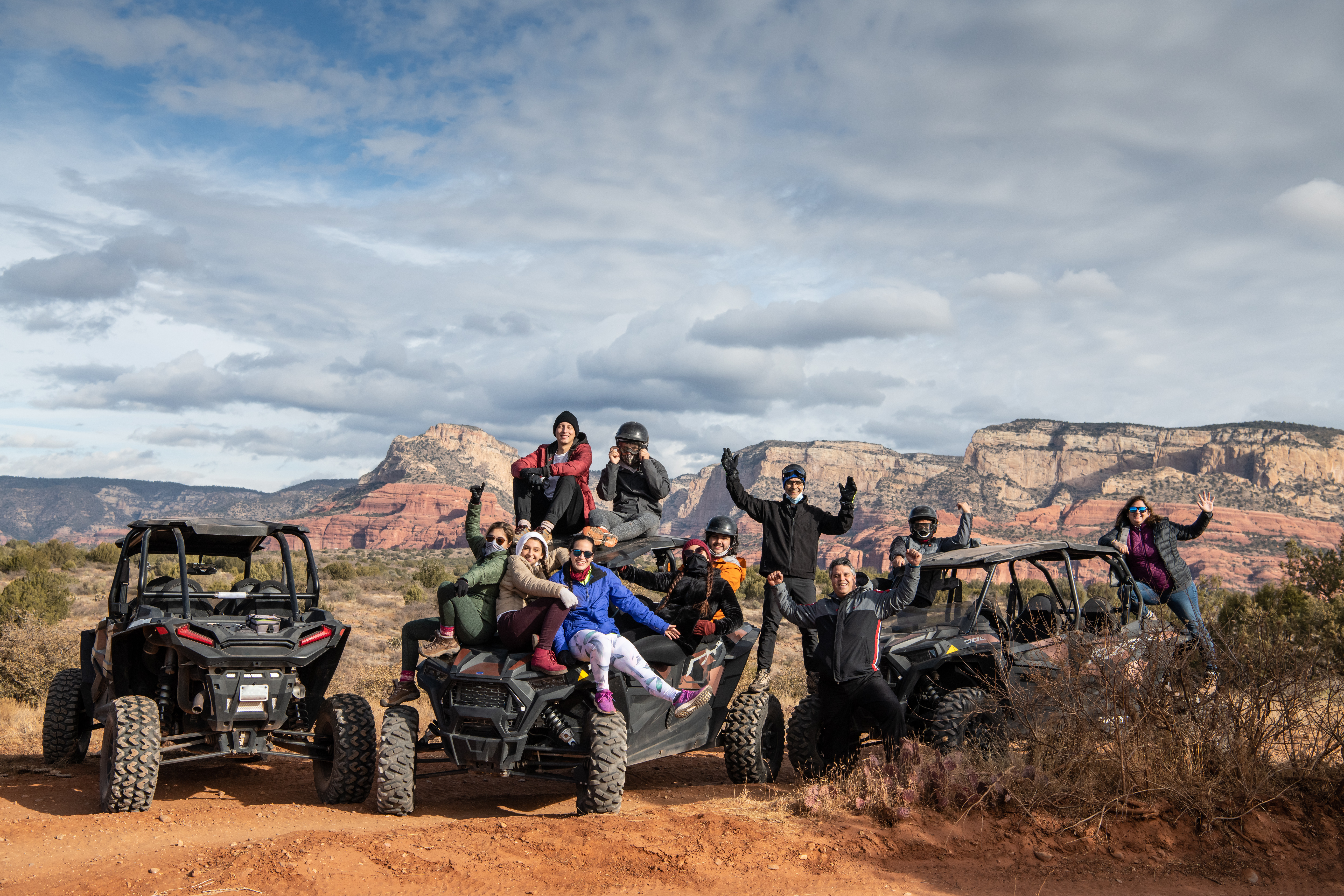 A group of friends celebrating on off-road ATVs in the Sedona desert