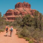 Couple hiking hand in hand toward Bell Rock on a Sedona trail